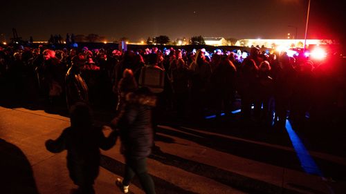 Thousands wait for shuttle buses following a Make America Great Again! campaign rally with President Donald Trump in Omaha.