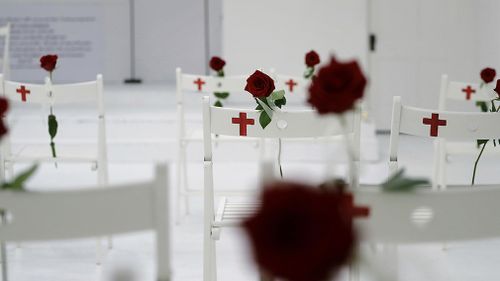 Twenty-six chairs were set up with roses in memory of each person killed in the shooting. (AAP)