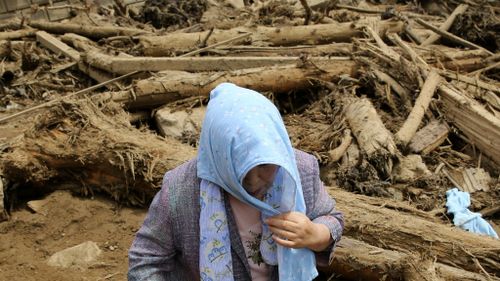 A local woman visits the site of a landslide to check if her house was damaged in the landslide. (Getty Images)