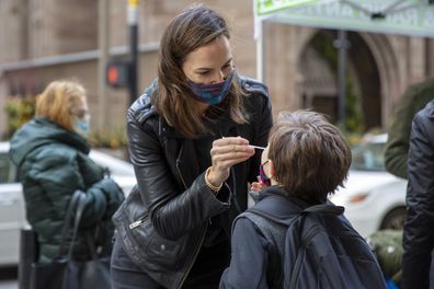 Katie Lucey administers a COVID-19 test on her son Maguire at a PCR and Rapid Antigen COVID-19 coronavirus test pop up on Wall Street in Manhattan in New York City on Thursday, December 16, 2021. 