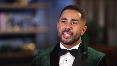 MAFS groom Adam speaking in a piece to camera. Wearing green velvet looking suit with buttoned-up white shirt and black bowtie.