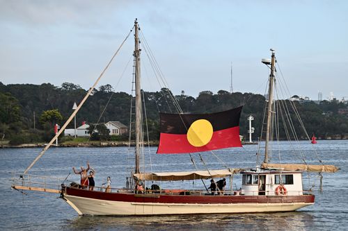 SYDNEY, AUSTRALIA - JANUARY 26: The Aboriginal flag attached to a boat as it passes the Sydney Harbour on Australia day on January 26, 2025 in Sydney, Australia. Australia Day, formerly known as Foundation Day, is the official national day of Australia and is celebrated annually on January 26 to commemorate the arrival of the First Fleet to Sydney in 1788. Many indigenous Australians refer to the day as 'Invasion Day' and there is a small but growing movement to change the date amid broader deba