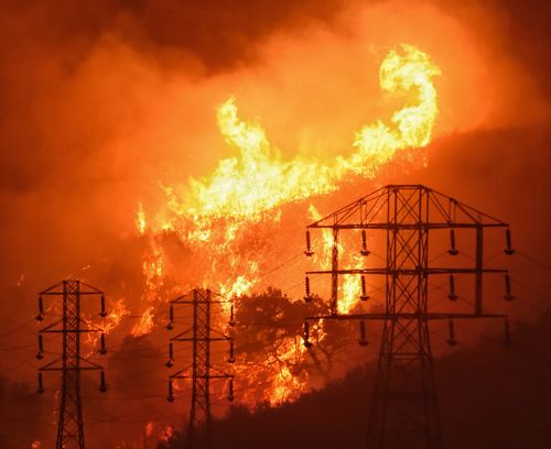 Flames burn near power lines in Sycamore Canyon near West Mountain Drive in Montecito. (AAP)