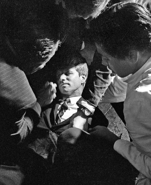 Hotel busboy Juan Romero, right, comes to the aid of Senator Robert F. Kennedy, as he lies on the floor of the Ambassador hotel in Los Angeles moments after he was shot