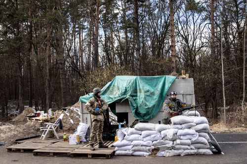 Members of the Ukrainian military wait at a forward position on the eastern frontline near Kalynivka village as Russian forces advance on Kyiv.