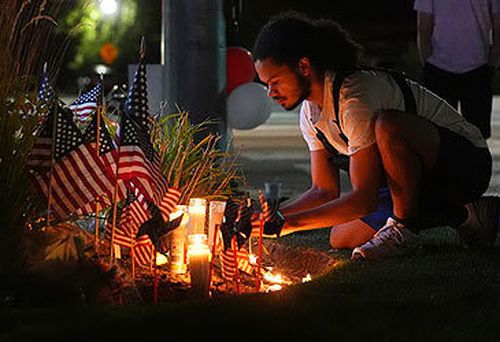 O homem organiza vela em vigília para Charlie Kirk, fora do Hospital Regional de Timpanogos (Lindsey Wasson/AP)