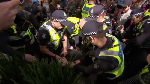 A number of police carried out the arrest of the masked man. (9NEWS)
