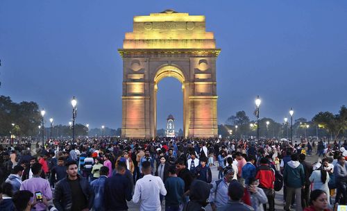 India Gate in New Delhi with a crowd of people celebrating New Year