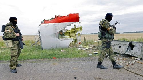 Armed rebel soldiers patrol at the main crash site of the Boeing 777 Malaysia Airlines flight MH17. (AAP)