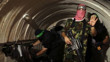 A Palestinian fighter from the Izz el-Deen al-Qassam Brigades, the armed wing of the Hamas movement, gestures inside an underground tunnel in Gaza in August 2014.