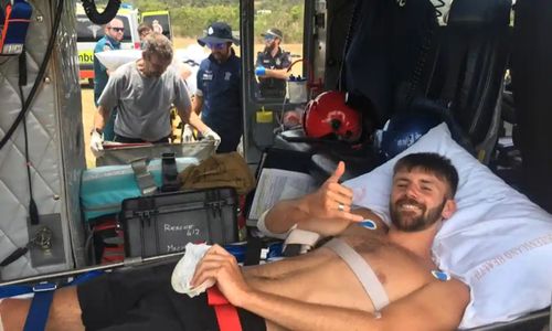Shark attack victim Danny Maggs, 22, in the rescue chopper. Maggs' right calf was lacerated in the sixth shark attack in the area in just over a year.