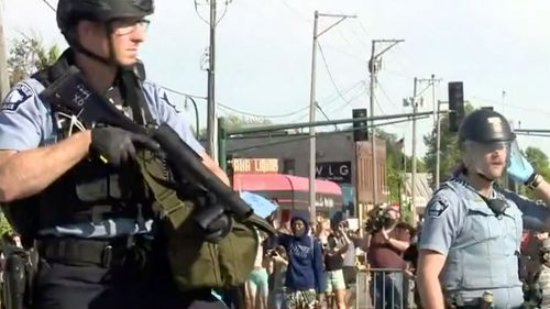 Armed police respond after a man was stabbed during riots in Minneapolis. 