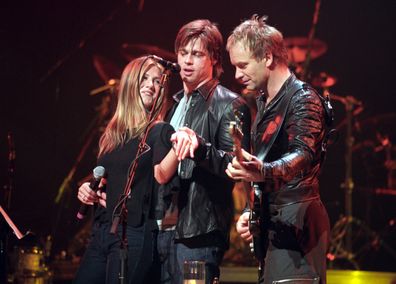 Jennifer Aniston and Brad Pitt show off Jennifer's engagement ring onstage at the Beacon Theater during a Sting concert on November 21, 1999.