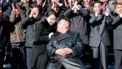 북한 지도자 김정은과 그의 딸이 과학자들과 노동자들과 함께 포즈를 취하고 있다.