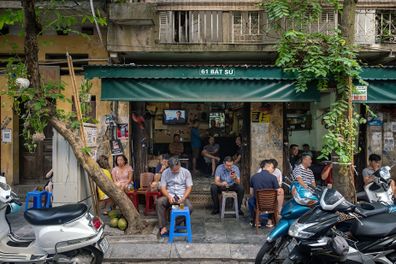 Customers sit at a coffee shop in Hanoi, Vietnam. 