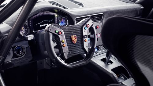 The interior features a gear knob finished in laminated wood, paying homage to the Carrera GT and Bergspyder.