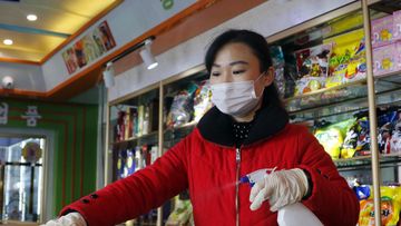 An employee of the Kyonghung Foodstuff General Store disinfects the showroom countertops in Pyongyang, North Korea in November 2021.
