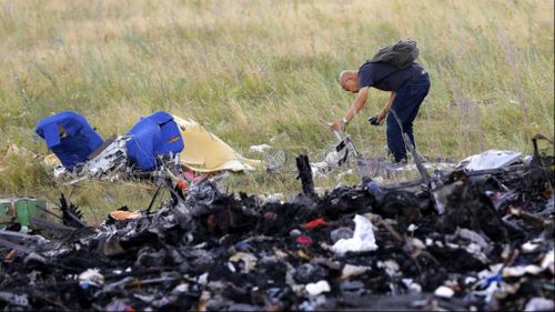 A Malaysian expert checks debris at the main crash site of flight MH17, which crashed flying over the eastern Ukraine region, near Grabovo, some 100 km east from Donetsk. Picture: AAP