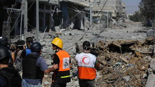 Non-governmental aid workers and media examine the devastation in Gaza. (AAP)