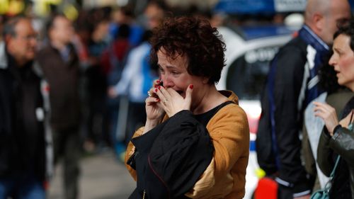 A woman cries outside the school where a teacher was reportedly killed. (AAP)