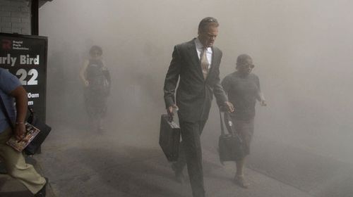 Pedestrians flee the dust-filled area surrounding the World Trade Center. (AAP)