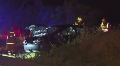 Emergency crews survey the wrecked car after the collision.