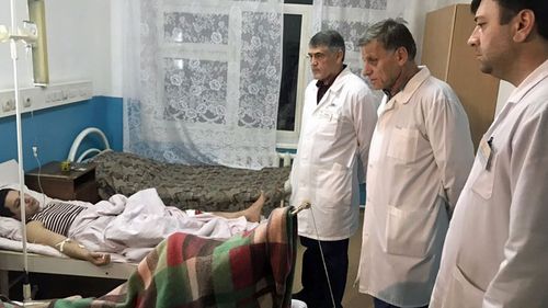 Doctors examine a wounded man in the hospital after a shooting near the church in Kizlyar Dagestan, Russia. (Photo: EPA).