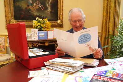 LONDON, ENGLAND - FEBRUARY 21: In this photo released on February 23, King Charles III reads cards and messages, sent by well-wishers following his cancer diagnosis, in the 18th Century Room of the Belgian Suite at Buckingham Palace on February 21, 2024 in London, England. Following the announcement of the King's cancer diagnosis, the Correspondence Team at Buckingham Palace have received more than 7,000 letters and cards form across the world. The King has been sent a selection in his daily red