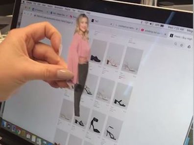 The woman uses a cut out of herself to try shoes.
