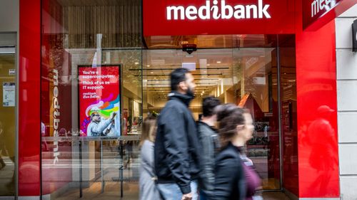 Les gens passent devant un point de vente Medibank à Sydney.