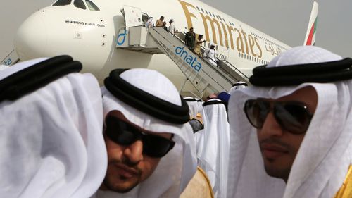 Emirati officials greet each other in front of an Emirates Airbus A380 on display during the opening day of the 2018 Dubai Airshow. (AP)