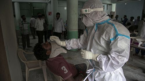 A health worker takes a nasal swab samples to test for COVID-19 in Gauhati, India.