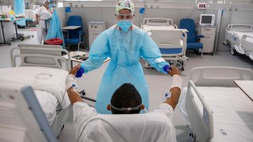 A physiotherapist treats a COVID-19 patient at the intermediate respiratory care unit in Nurse Isabel Zendal Emergency Hospital in Madrid, Spain.