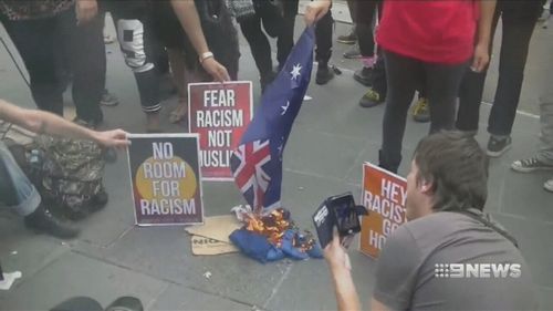 Members of the Warriors of the Aboriginal Resistance burn an Australian flag. 