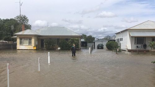 A Birchip resident stands in floodwaters.