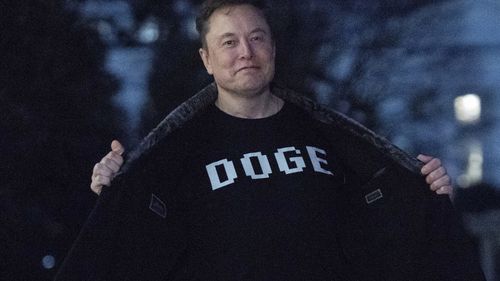 FILE - Elon Musk flashes his T-shirt that reads "DOGE" to the media as he walks on South Lawn of the White House, in Washington, March 9, 2025. (AP Photo/Jose Luis Magana, File)