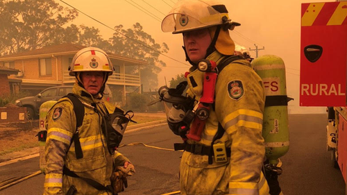 Greg Mullins (left) pictured on New Years Eve 2019 at Batemans Bay 'after extinguishing one of many burning homes'.