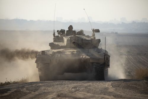 An Israeli tank moves along the border with the Gaza Strip as seen from a position on the Israeli side of the border in Southern Israel.