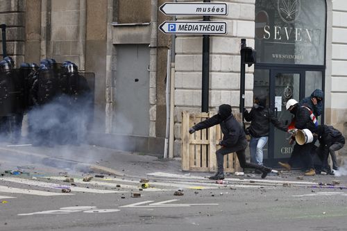 Youths clash with riot police officers during a protest Thursday, April 6, 2023 in Nantes, western France.  