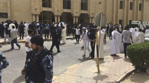 Security forces, officials and civilians gather outside of the Imam Sadiq Mosque in Kuwait City. (AAP)