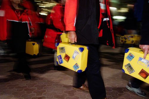 The opening ceremony crowd leaving Stadium Australia after the event finished with their complimentary yellow suitcases in hand. Picture by Glen Watson.