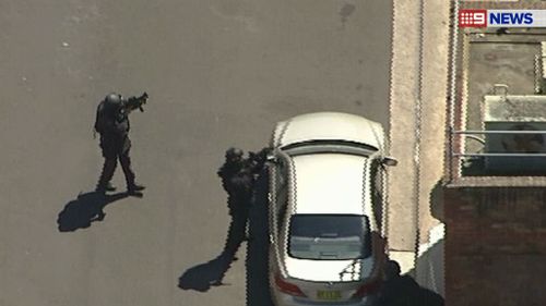 Tactical response teams have guns trained on the building. (9NEWS)