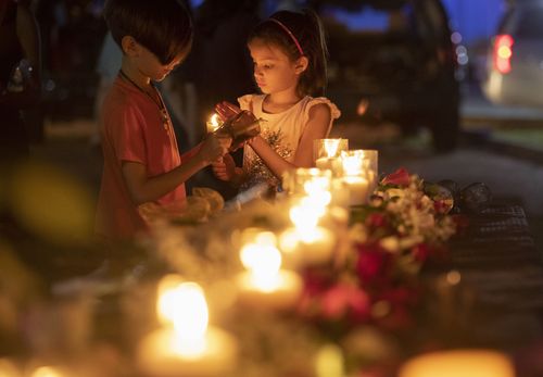 Lucrecia Martinez, 7, and her brother Luciano, 9, of Dickinson light candles at the vigil. Picture: AP