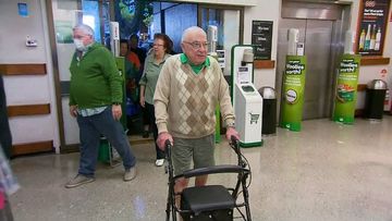 An elderly man arrives at Woolworths to collect essential items before the general public arrives.