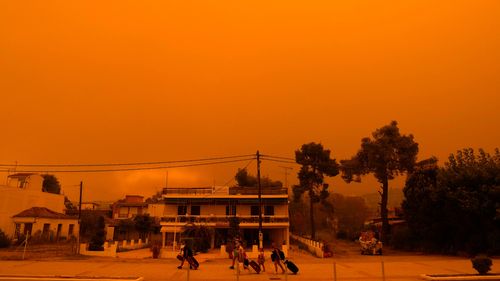 People evacuate during a wildfire Pefki village on Evia island, about 189 kilometres north of Athens, Greece.