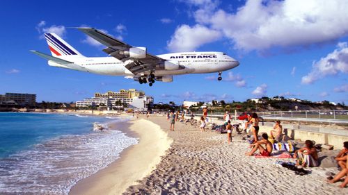 Thrill seekers come to Maho beach in droves to snap a picture with planes flying overhead. (AFP)