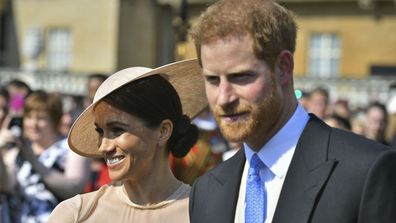 Meghan Markle, the Duchess of Sussex walks with her husband, Prince Harry as they attend a garden party at Buckingham Palace in London, Tuesday May 22, 2018. The event is part of the celebrations to mark the 70th birthday of Prince Charles. 