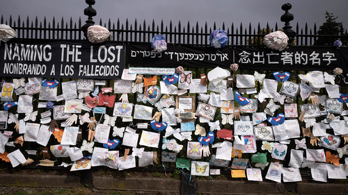 FILE - In this Thursday, May 28, 2020 file photo, a fence outside Brooklyn's Green-Wood Cemetery is adorned with tributes to victims of COVID-19 in New York. 