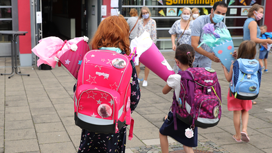 OBERPLEIS, GERMANY - AUGUST 13: First graders arrive with goodie bags for their first introductory day to school during the coronavirus pandemic on August 13, 2020 in Oberpleis near Bonn, Germany.