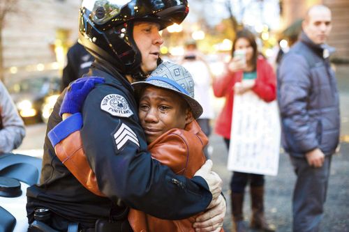 A Portland officer saw his sign and asked if he could have a hug, and an emotional Devonte embraced him in a picture that was widely shared. (AAP)